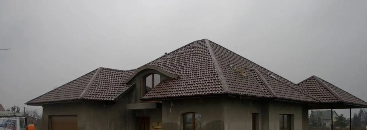 Dach wielospadowy z brązowej blachodachówki z lukarną — BLACHBUD