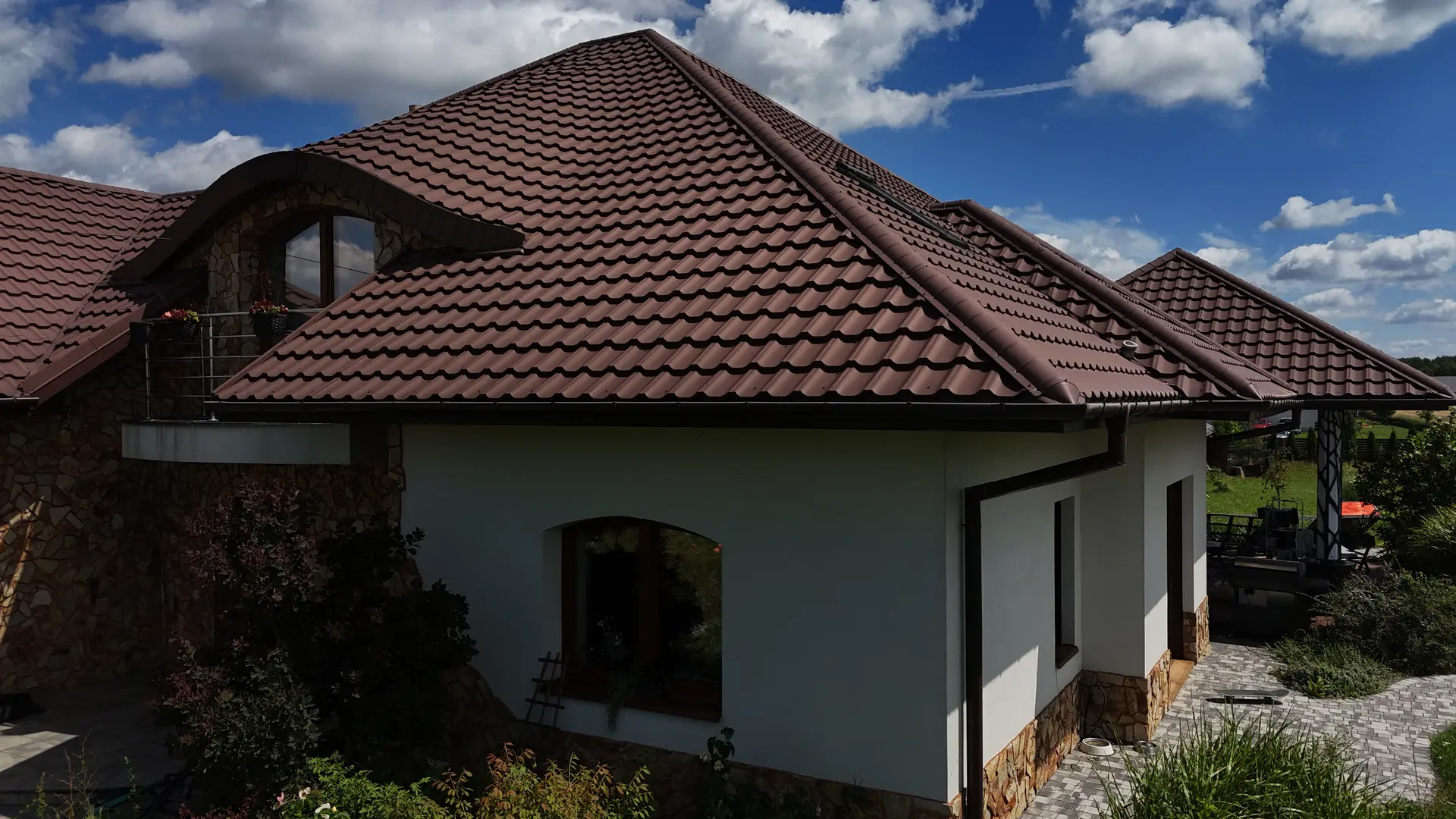 Dach wielospadowy z brązowej blachodachówki z lukarną — BLACHBUD